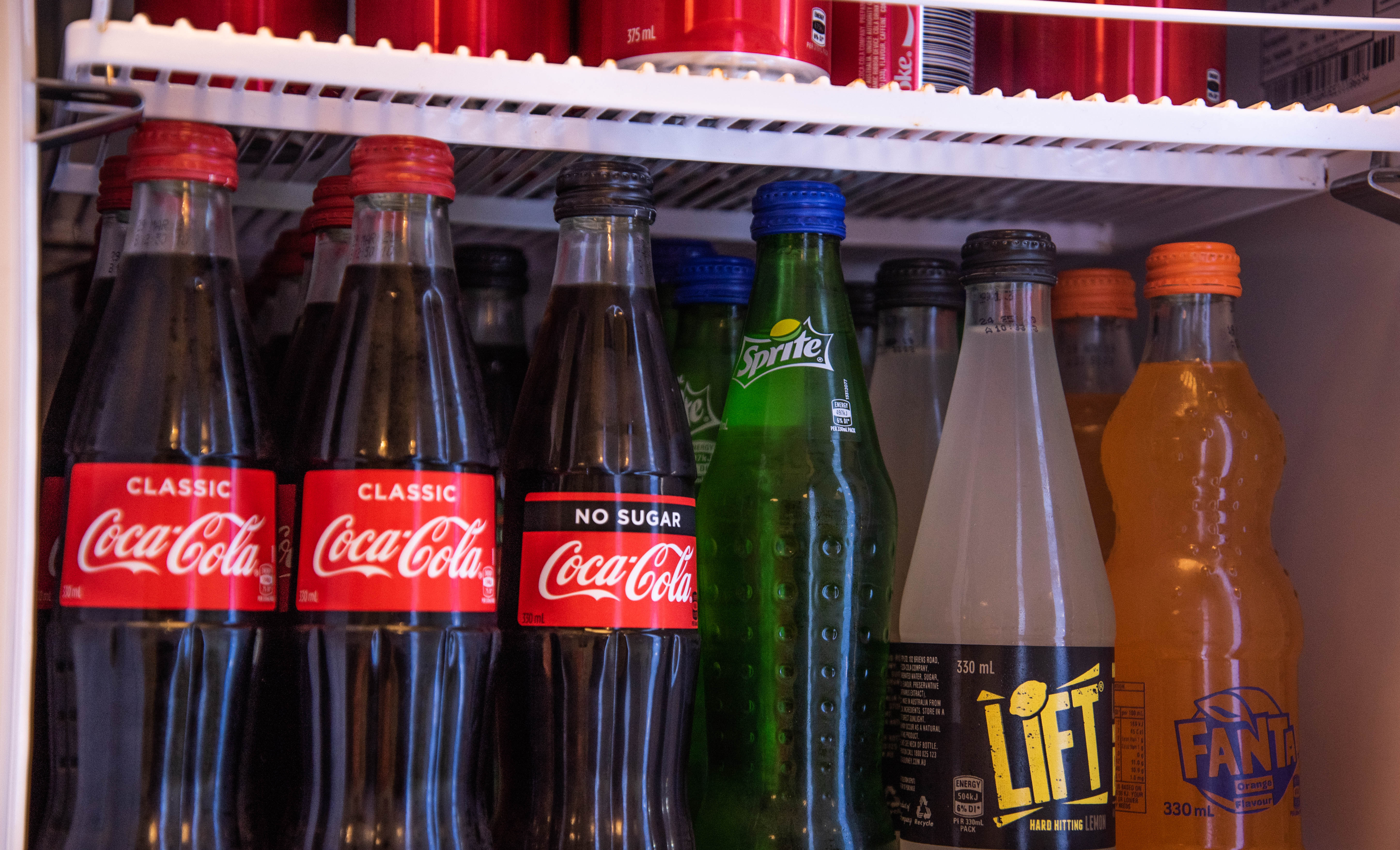 Bottled soft drinks on display at convenience store.